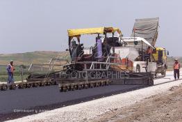 Image du Maroc Professionnelle de  Travaux sur la voie en construction Sidi el Yamani-Asilah installation de la première épaisseur de la couche de revêtement de la chaussée, Mercredi 12 Juin 2002. (Photo / Abdeljalil Bounhar) 